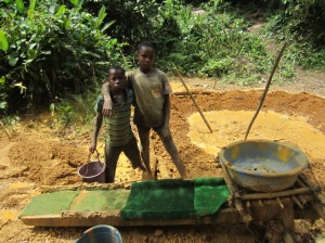 Two young gold prospectors pose near the washing table